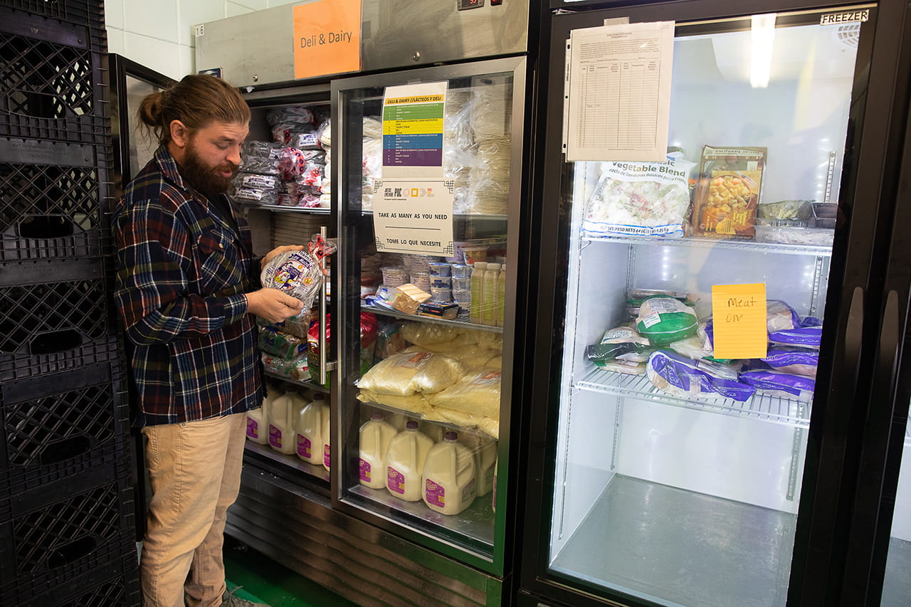 guy checking food in a refrigerator