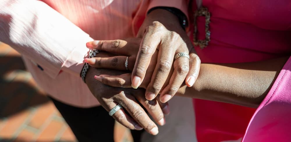 A closeup of a Valentine’s Day wedding couple’s hands showing new wedding rings.