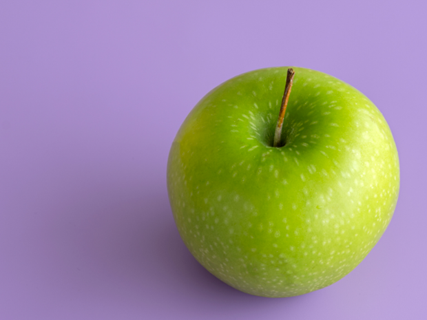 green apple on purple background