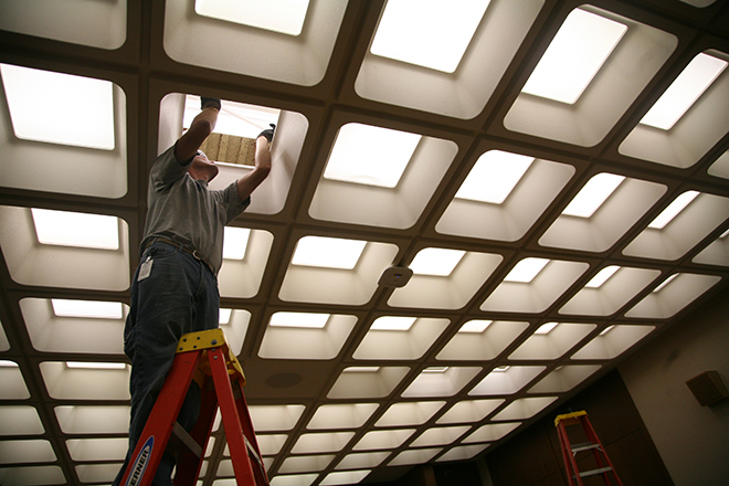 Person on a ladder changing a light fixture