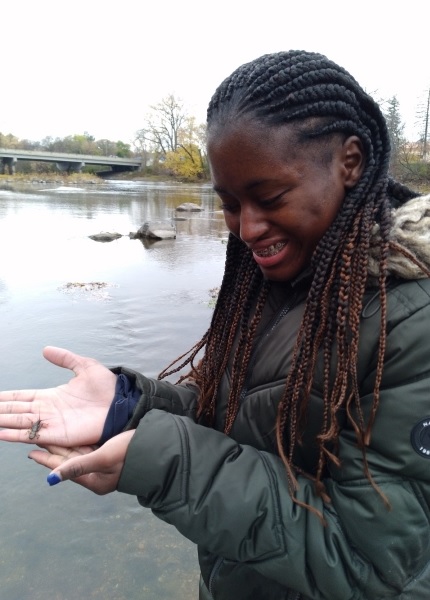 Young woman holding small insect