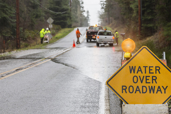 Emergency crew working on a road that is flooded
