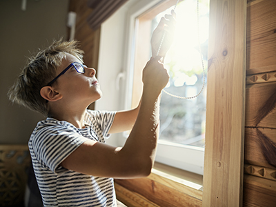 Boy closing blinds