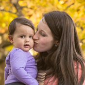 Mom kissing baby on cheek