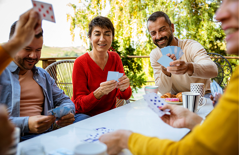 friends outside at a table playing cards